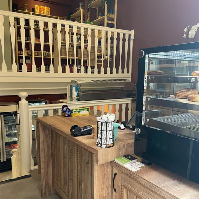 Winkelbalie met de vitrine met gebak en op de achtergrond de voorraadschappen boven
