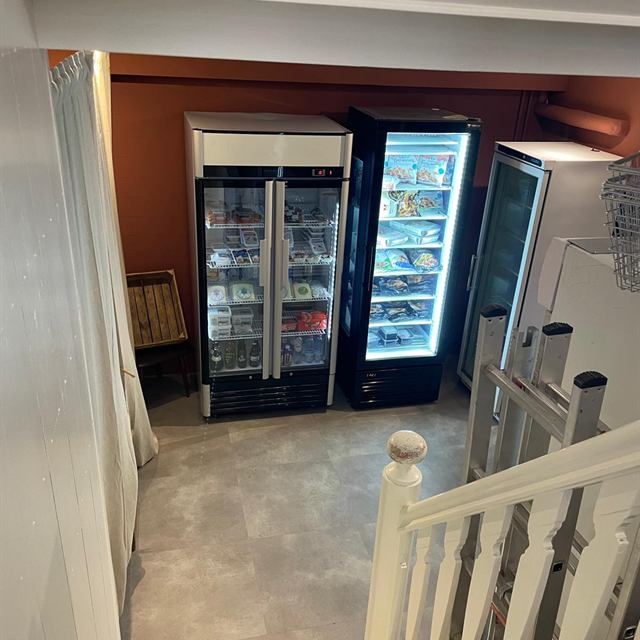 Koelkasten en vriezer met zuivel en diepvriesproducten op de onderverdieping van Bakaliko Amsterdam