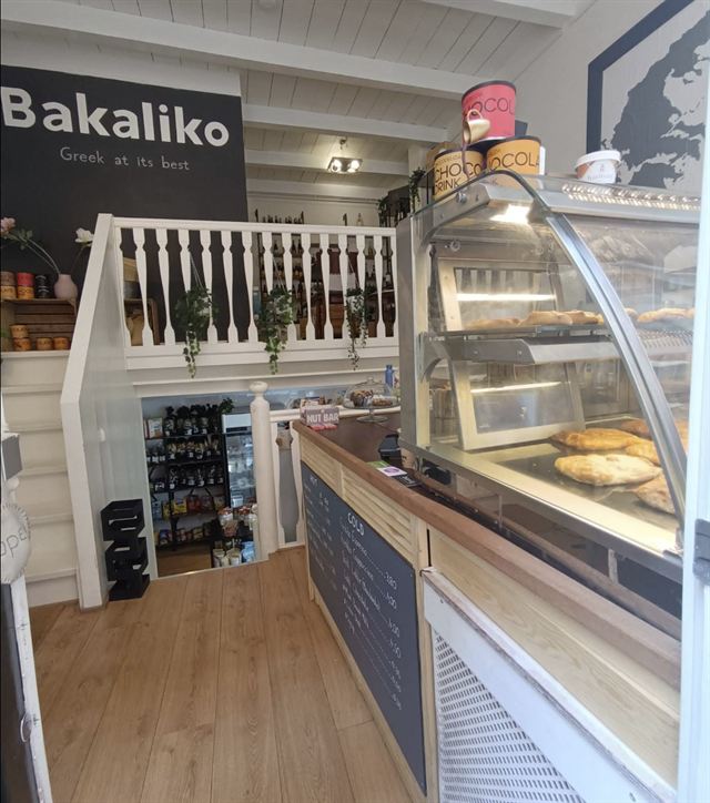 Vitrine met Griekse pies en gebak naast de koffiebalie bij Bakaliko Amsterdam