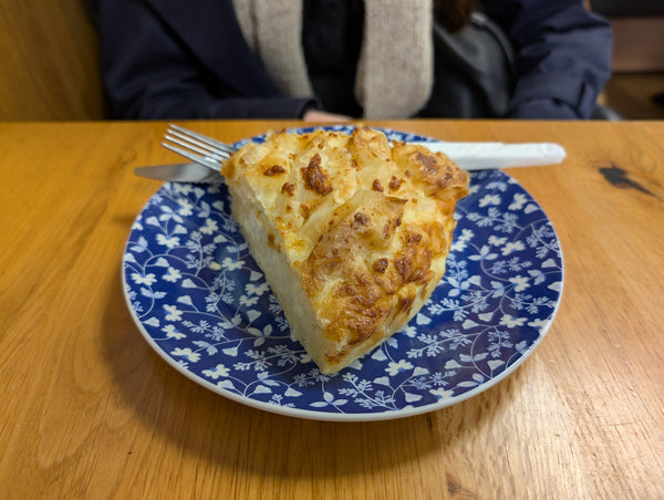Slice of Greek feta pie in filo on a blue plate