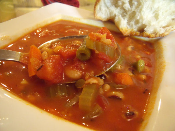 Bowl of black-eyed bean soup in tomato broth with celery and carrot
