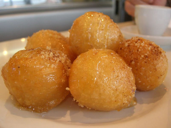 Loukoumades, gefrituurde deegballetjes met honing en sesam