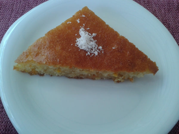 Slice of revani semolina cake topped with lemon zest