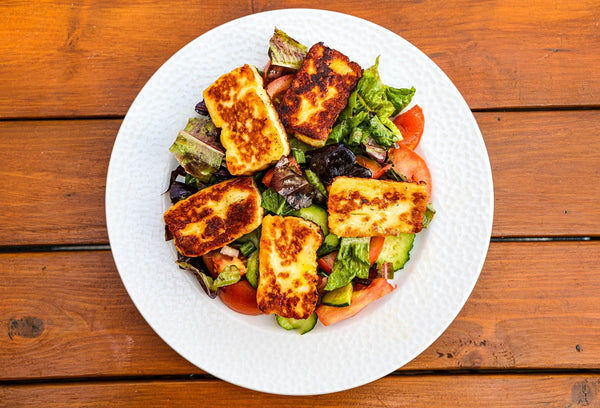Gegrilde plakken halloumi op een gemengde salade