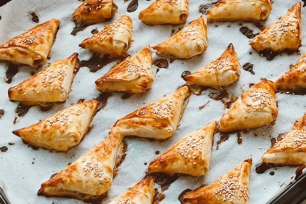 Golden triangular filo pastries with sesame