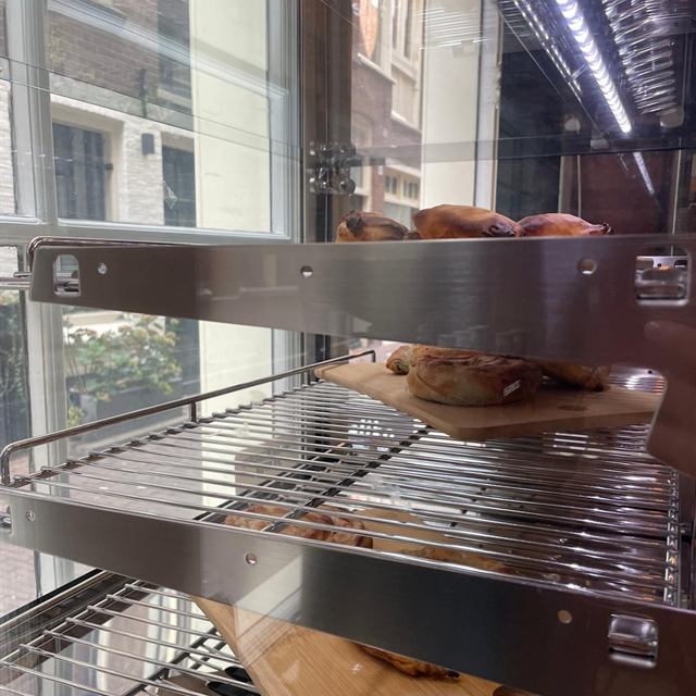 Vitrine met Griekse pies en gebak op houten planken